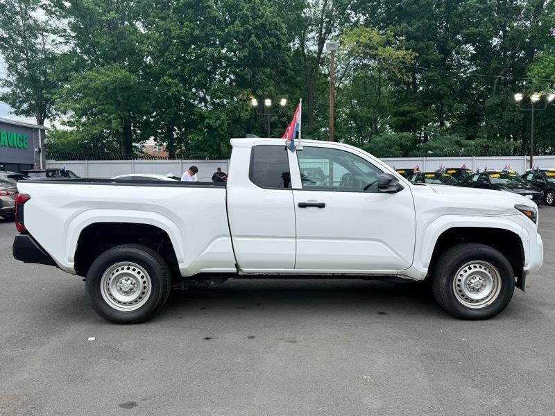 Side view of a white pickup truck with a flag at Garden State Auto Boutique.
