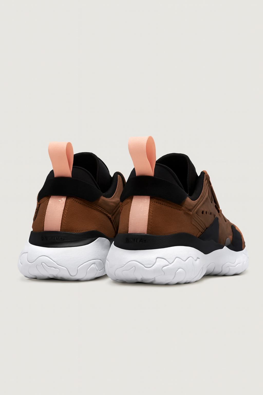 Parte trasera de dos zapatillas marrones y negras con suela blanca
